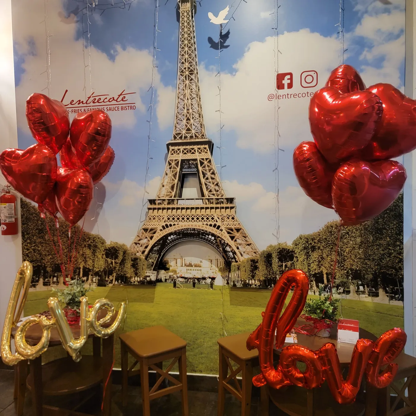 The Paris photo wall inside Lentrecote in Sunny Isles Beach, with the Eiffel Tower and red heart balloons