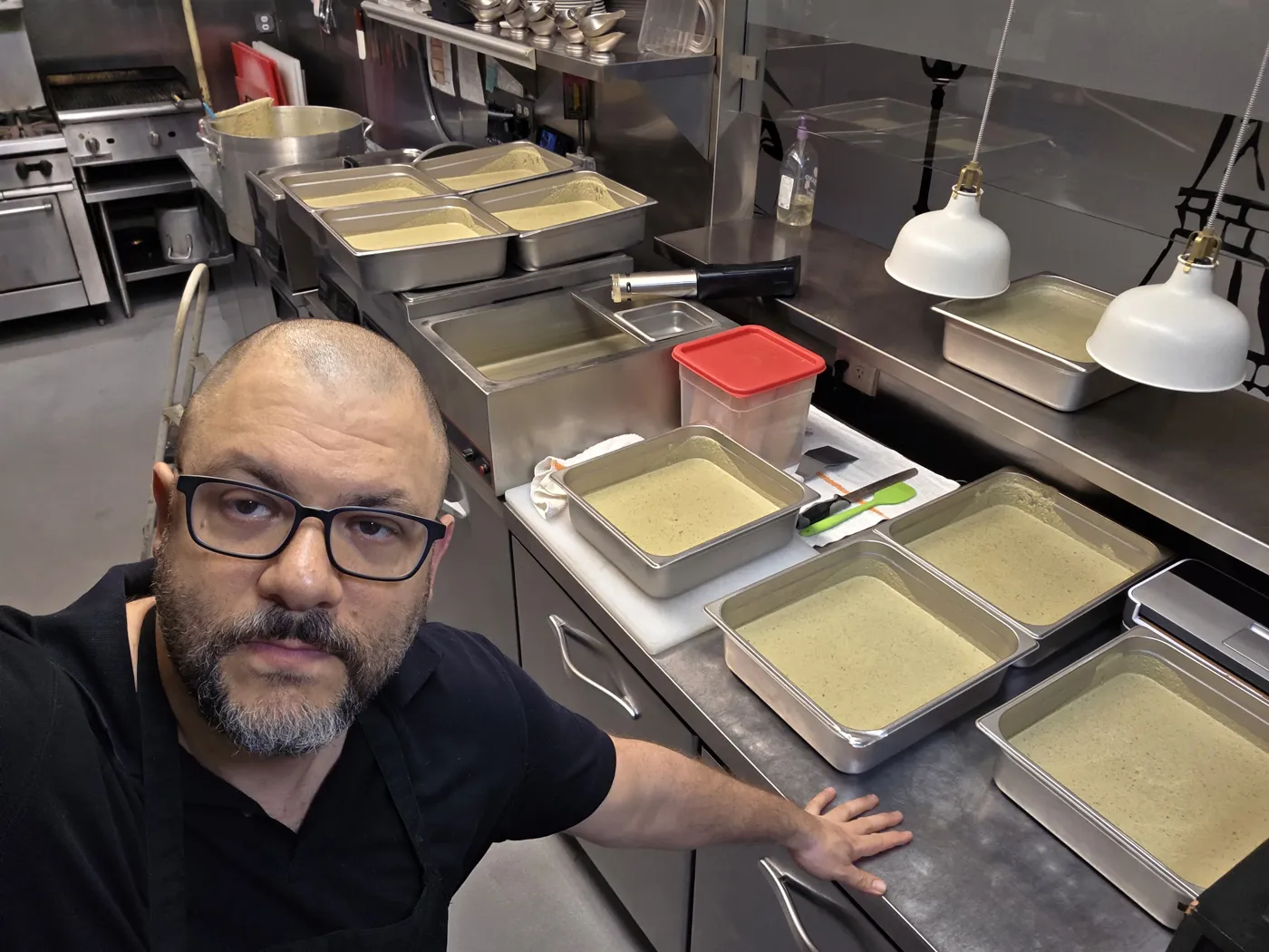 Ronald Szkolnik, owner and executive chef of Lentrecote, in the kitchen with trays of the house herb-butter sauce